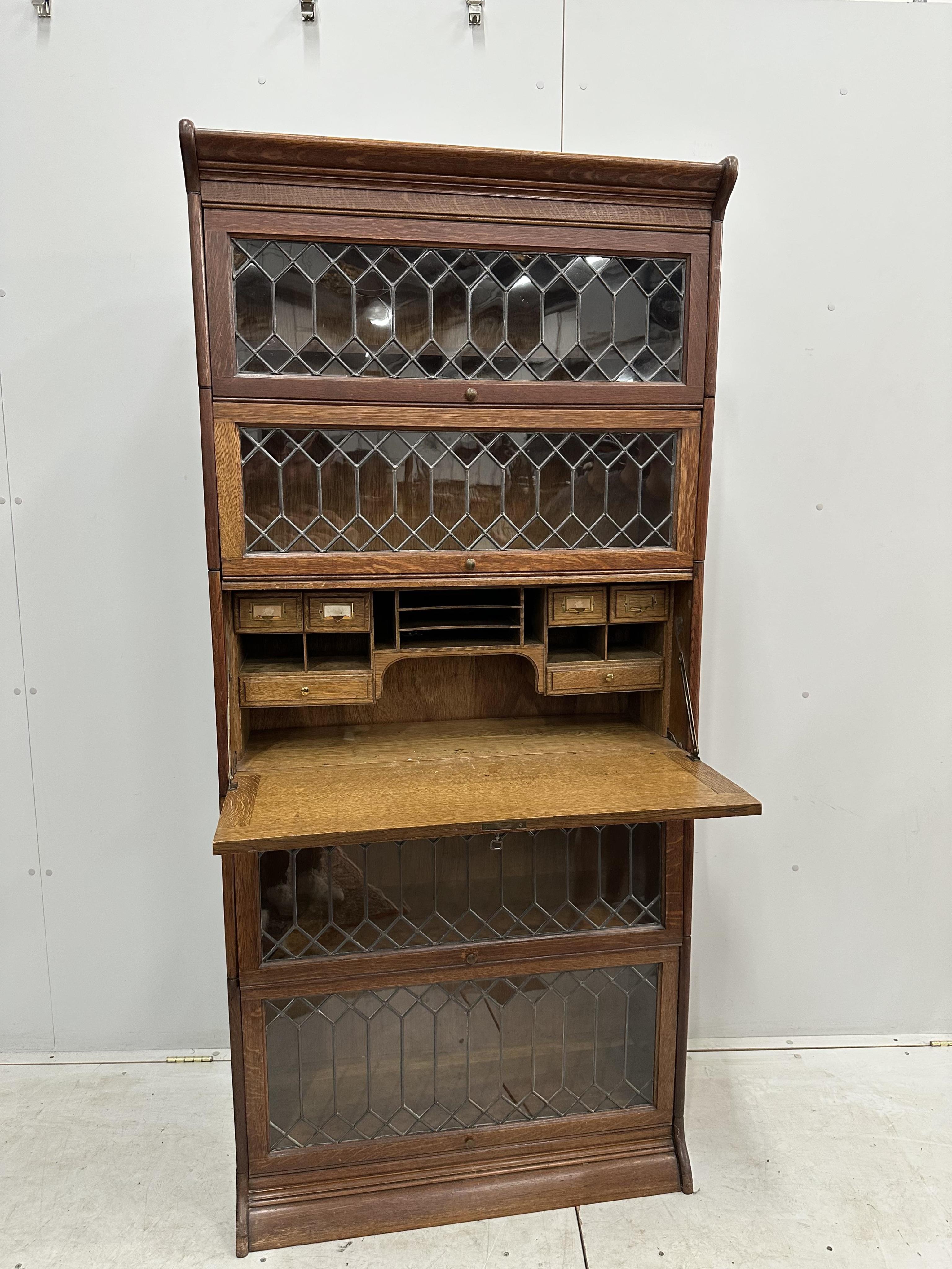 Attributed to Globe Wernicke, an oak five section bookcase incorporating secretaire compartment, width 87cm, height 190cm. Condition - good restored, back panels have been replaced